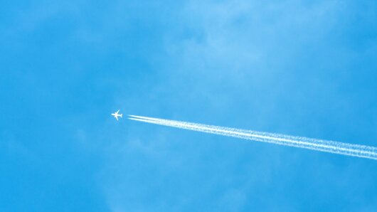 Himmel mit Flugzeug und Kondensstreifen