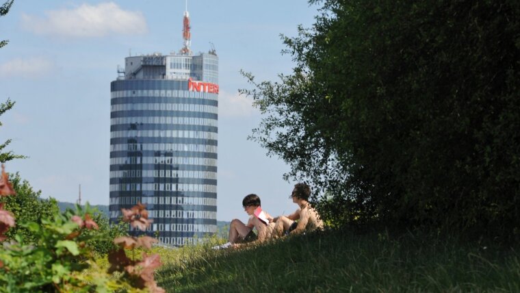 Studierende beim Lernen auf der Wiese vom Friedensberg mit Blick auf die Stadt Jena und den Landgrafen